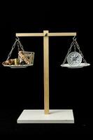 a balance scale with a clock and money on it photo