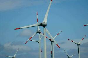 many wind turbines are standing in a field photo