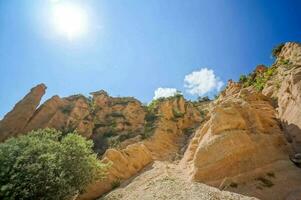 the sun shines brightly on the rocky cliffs photo