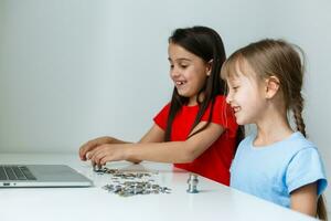 retrato de pequeño muchachas sentado a mesa y calculador dinero foto