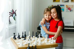 dos lindos niños jugando al ajedrez en casa foto