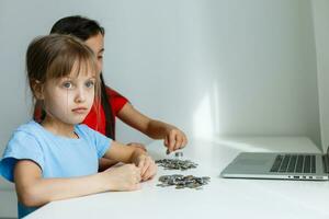 retrato de pequeño muchachas sentado a mesa y calculador dinero foto