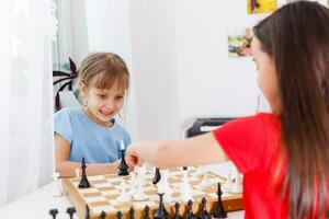 Two cute children playing chess at home photo