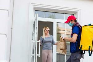 delivery man with thermo backpack and smiling woman in office photo