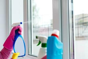 Woman cleaning a window with cleaning sprayer. photo