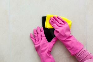 Cleaning the smartphone screen with a fiber cloth from dirt dust and other external factors. Mobile Care Concept photo