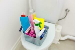 Basket with cleaning items on blurry background photo