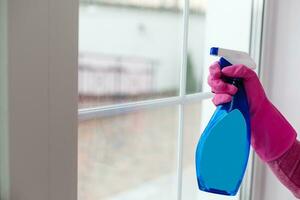 Woman cleaning a window with yellow cloth photo