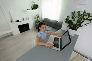 Pretty stylish schoolgirl studying homework math during her online lesson at home, social distance during quarantine, self-isolation, online education concept, home schooler photo