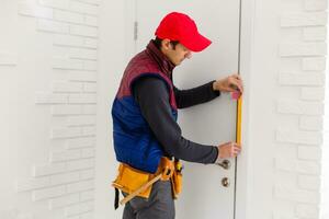 Young repairman adjusting a terrace door handle with screwdriver photo