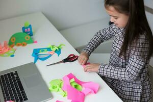 Pretty stylish schoolgirl studying homework math during her online lesson at home, social distance during quarantine, self-isolation, online education concept, home schooler photo