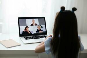 Pretty stylish schoolgirl studying homework math during her online lesson at home, social distance during quarantine, self-isolation, online education concept, home schooler photo