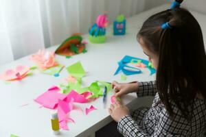 casual indoor portrait of child girl with laptop, portrait of young child girl crafting at home photo