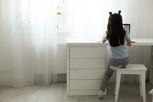 little girl studying with laptop online learning photo