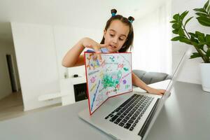 little girl studying with laptop online learning photo