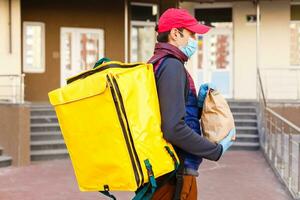 delivery man send food bag at door knob for contactless or contact free from delivery rider in front house for social distancing for infection risk. photo