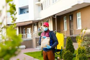 delivery man send food bag at door knob for contactless or contact free from delivery rider in front house for social distancing for infection risk. photo