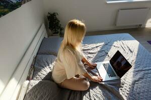Woman using a laptop while relaxing on the couch photo