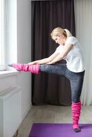 Beautiful young woman doing exercises at home photo