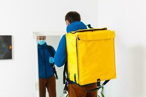 Young courier with thermo bag on white background. Food delivery service photo