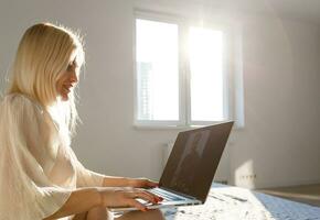 Middle-aged woman working from home on laptop photo