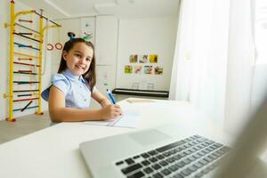 little girl studying with laptop online learning photo