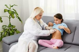 Doctor examining a little girl by stethoscope. Medicine and health care concept. photo