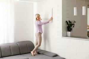 woman holds photo canvas at home