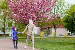 mother and little young daughter wearing mask for prevent dusk pm 2.5 bad air pollution on deck in city 2020. photo