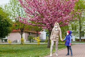 mother and little young daughter wearing mask for prevent dusk pm 2.5 bad air pollution on deck in city 2020. photo