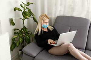 Woman in quarantine for Coronavirus wearing protective mask and smart working photo