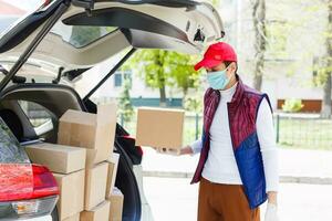 Grocery delivery man wearing medical gloves and face mask. Online shopping and delivery for grocerys, wine and food. Self Quarantine during coronavirus pandemic. Food delivery service courier photo