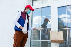 tienda de comestibles entrega hombre vistiendo médico guantes y cara mascarilla. en línea compras y entrega para comestibles, vino y alimento. yo cuarentena durante coronavirus pandemia. comida entrega Servicio mensajero foto