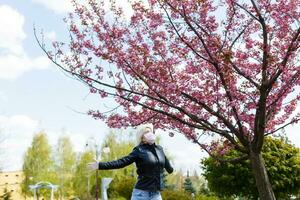 contento joven mujer vistiendo facial máscara para virus proteccion en pie al aire libre en soleado primavera día. foto