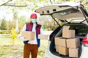 Grocery delivery man wearing medical gloves and face mask. Online shopping and delivery for grocerys, wine and food. Self Quarantine during coronavirus pandemic. Food delivery service courier photo