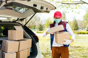 Man with face mask is delivering food and groceries during virus epidemic. photo