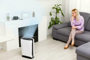 Air purifier , Business woman use filter for clean room in a living room photo