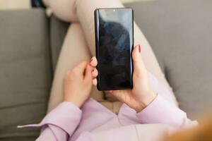 Young woman using apps on a mobile touchscreen smartphone. Concept for using technology, shopping online, mobile apps, texting, addiction, swipe up, swipe down. photo