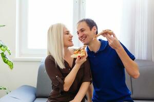 joven Pareja comiendo Pizza a hogar foto