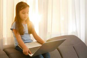 little girl studying with computer photo