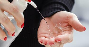 Female hands applying antibacterial liquid soap close up. photo