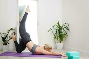 Living room fitness workout girl doing exercises at home. Young woman training muscles, healthy lifestyle without going to the gym. photo