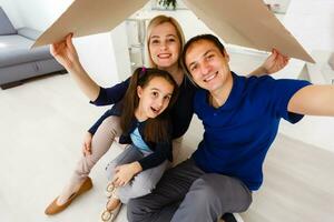 concept housing a young family. Mother father and child in new house with a roof photo