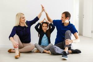 concept housing a young family. Mother father and child in new house with a roof photo