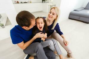 playful family sitting and smiling indoors photo