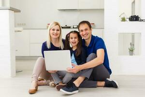 Family top view sitting on floor using laptop computer in her room at home photo