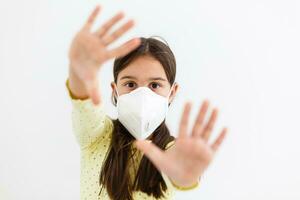 Masked child - protection against influenza virus. Little Caucasian girl wearing mask for protect pm2.5. Biological weapons. baby on a gray background with copy space. epidemic, pandemic. photo