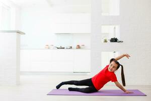 smiling little girl doing exercises at home photo