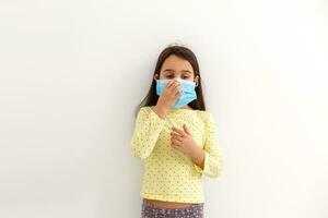 little girl in a disposable mask on a light background. corona virus epidemic protection photo