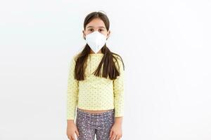 Masked child - protection against influenza virus. Little Caucasian girl wearing mask for protect pm2.5. Biological weapons. baby on a gray background with copy space. epidemic, pandemic. photo